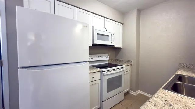 a kitchen with a white cabinets and white appliances