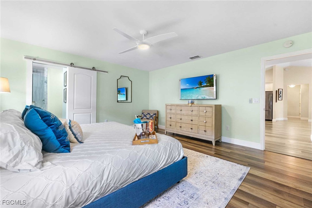 2307 Southwest 40th Street Cape Coral, FL 33914 - Photo 11 of 36 a bedroom with a bed and wooden floor