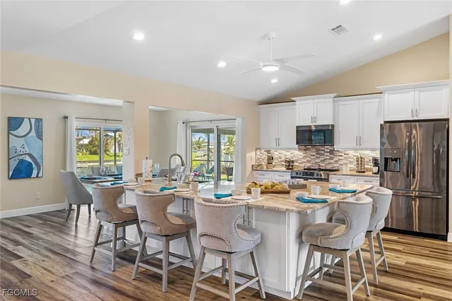a kitchen with a dining table chairs refrigerator and cabinets