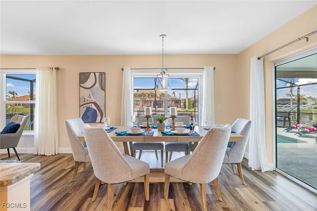 a dining room with furniture a chandelier and wooden floor