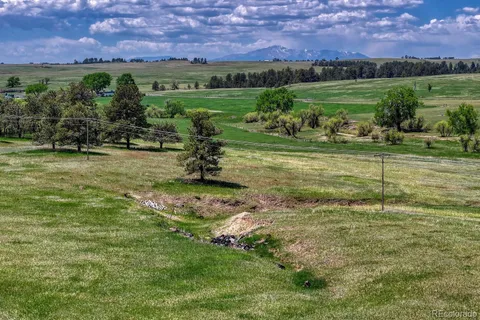 a big yard with lots of green space and mountain view in back