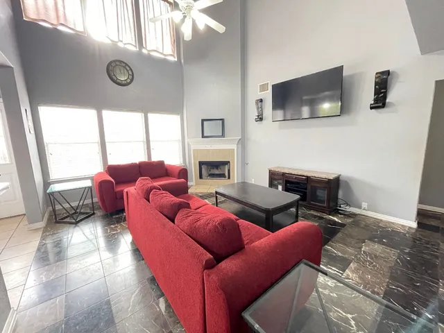 a living room with furniture a flat screen tv and a fireplace