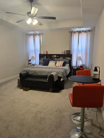 a spacious bedroom with a bed a window and a chandelier