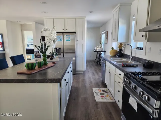 a kitchen with granite countertop a stove and a wooden floor