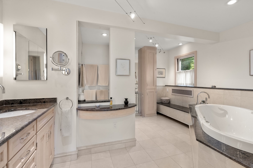 48 Hubbard Park Road Cambridge, MA 02138 - Photo 17 of 31 a bathroom with a granite countertop sink a bathtub a mirror and vanity