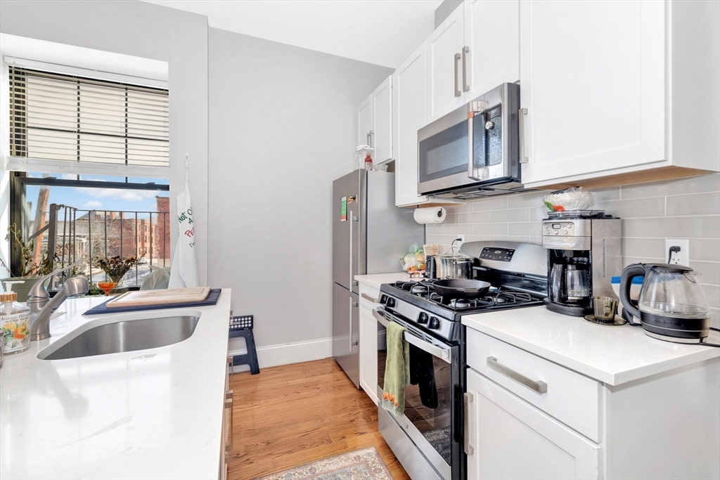 27 Dudley Street Boston, MA 02119 - Photo 21 of 42 a kitchen with stainless steel appliances a sink a stove and microwave
