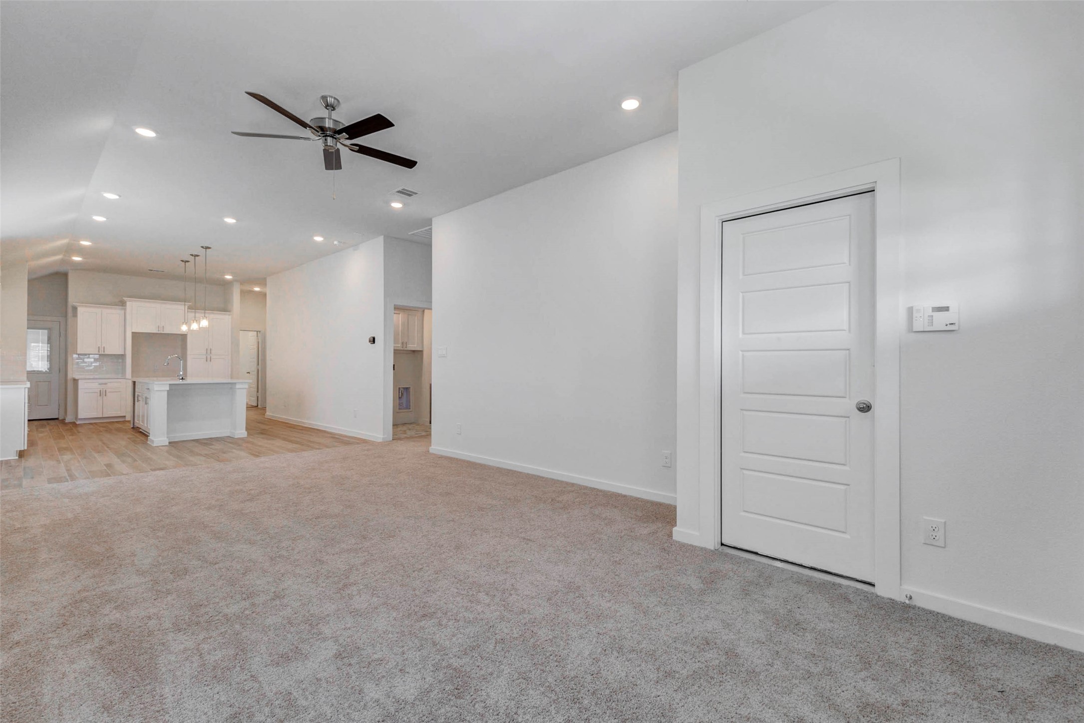 6463 Escondido Drive Rosharon, TX 77583 - Photo 8 of 30 Spacious open living area with soft carpet, high ceilings, recessed lighting, ceiling fan, and direct sightlines into the kitchen and dining area. The open layout creates an easy flow for everyday living, relaxing, and entertaining.