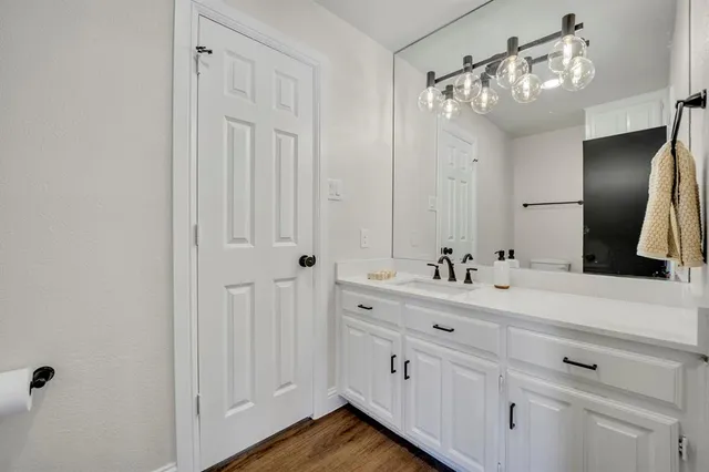 a bathroom with a double vanity sink a mirror and a bathtub