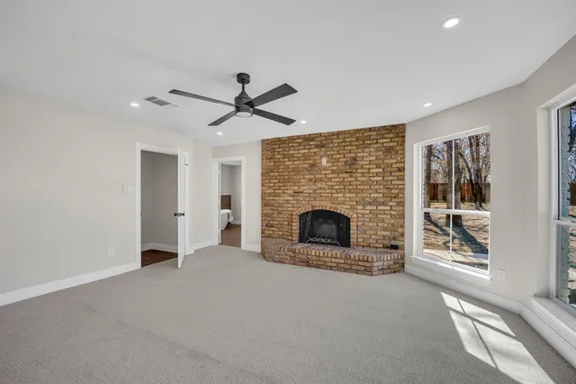 a living room with a fireplace and a ceiling fan