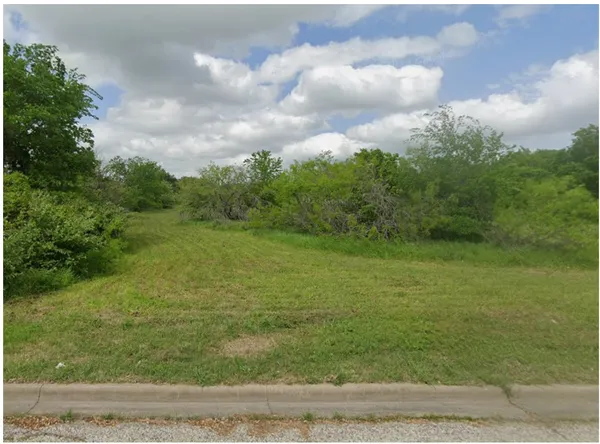 a view of a big yard with lots of green space