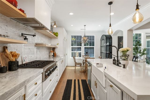 a kitchen with stainless steel appliances a stove a sink a counter space and a window