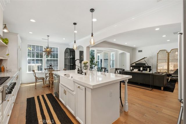 a large white kitchen with a large island in the center