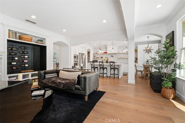 a living room with furniture a potted plant and open kitchen view