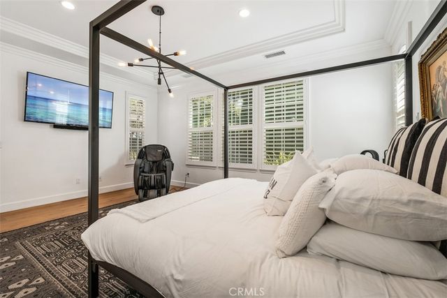 a bedroom with a large bed and a flat tv screen