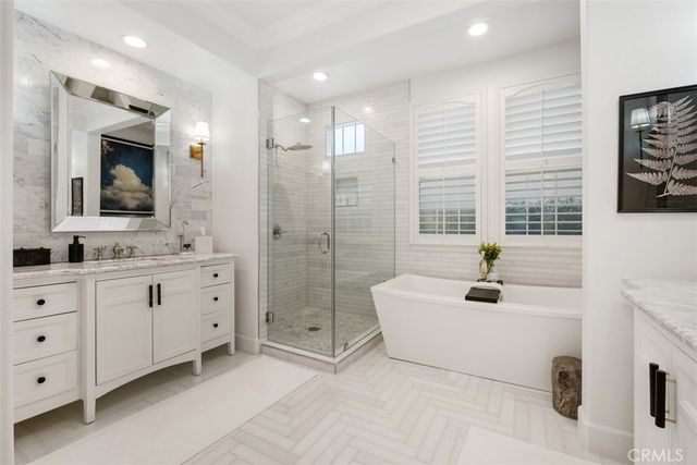 a spacious bathroom with a tub sink and mirror