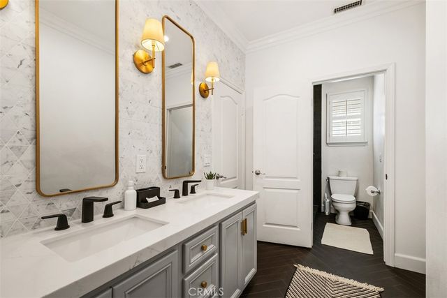 a white toilet sitting next to a bathroom sink