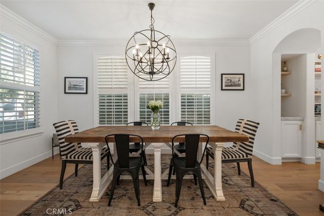 a view of a dining room and livingroom with furniture wooden floor and a chandelier