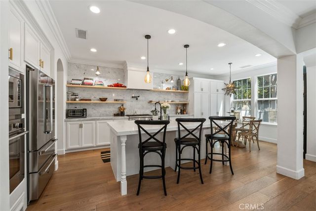 a kitchen with kitchen island granite countertop wooden cabinets and stainless steel appliances