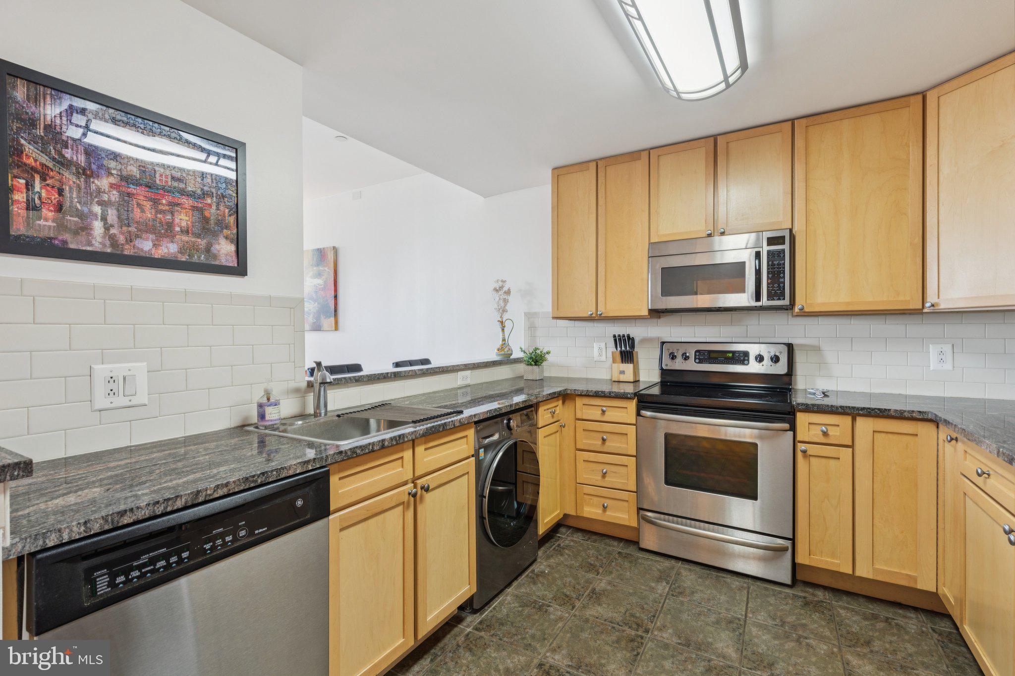 111 South 15th Street, Unit 2106 Philadelphia, PA 19102 - Photo 13 of 31 a kitchen with stainless steel appliances granite countertop a stove a sink and a microwave