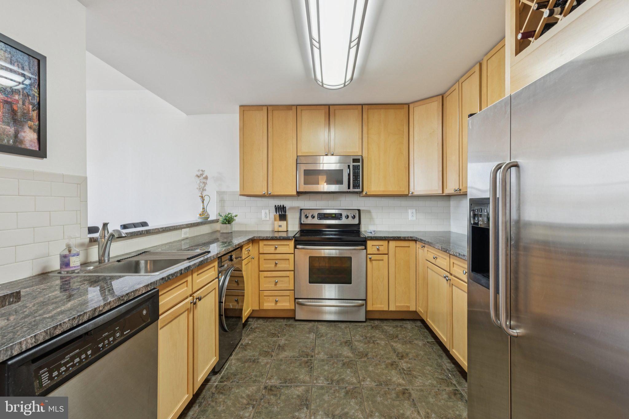 111 South 15th Street, Unit 2106 Philadelphia, PA 19102 - Photo 14 of 31 a kitchen with stainless steel appliances granite countertop a sink a stove and a refrigerator