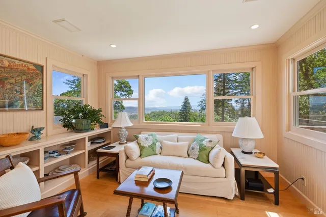 a living room with furniture a flat screen tv and a floor to ceiling window