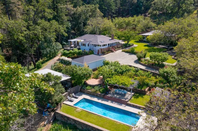an aerial view of a house with a garden and lake view