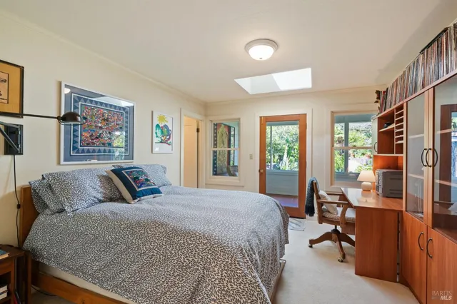 a bedroom with a bed a couch and a dresser next to a window
