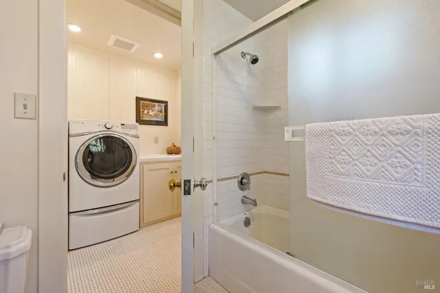 a bedroom with a large bed and dresser with mirror