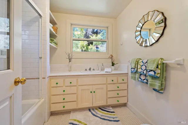 a spacious bathroom with a granite countertop sink mirror and a bathtub