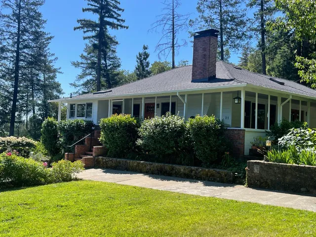 a front view of a house with yard and green space