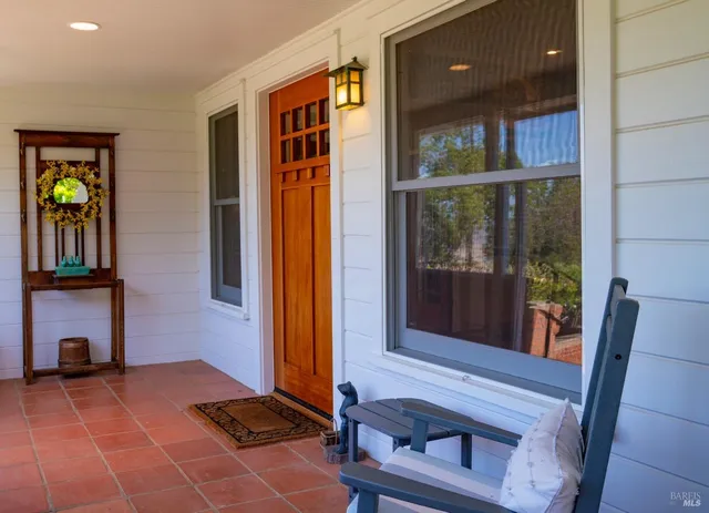 a view of a hallway with wooden floor and a dining table