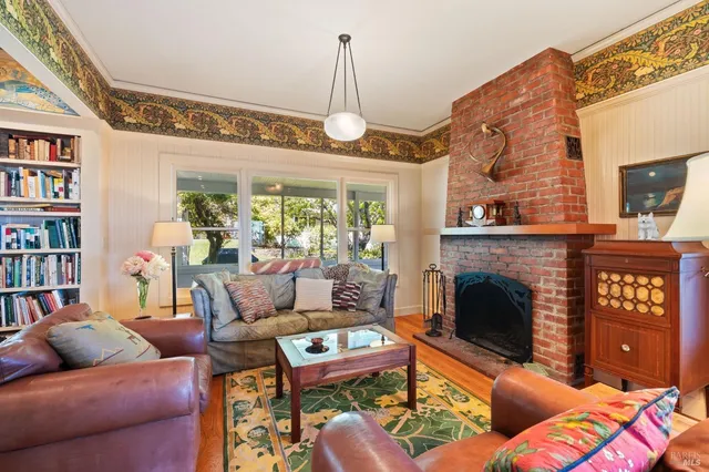 a living room with fireplace furniture and a book shelf