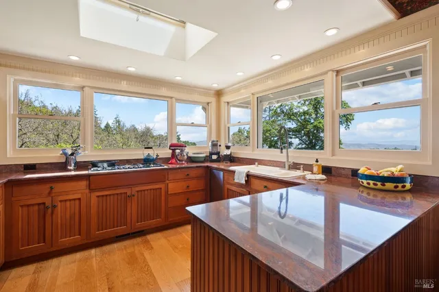 a kitchen with a large window and cabinets