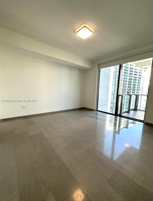 68 Southeast 6th Street, Unit 2507 Miami, FL 33131 - Photo 12 of 46 an empty room with wooden floor and windows