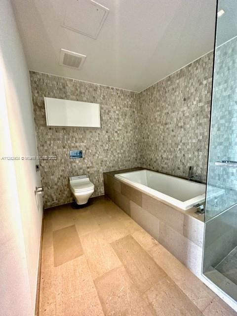 68 Southeast 6th Street, Unit 2507 Miami, FL 33131 - Photo 16 of 46 a bathroom with a granite countertop bathtub and a shower