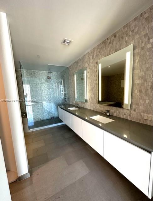 68 Southeast 6th Street, Unit 2507 Miami, FL 33131 - Photo 19 of 46 a bathroom with a sink a large mirror and a bathtub