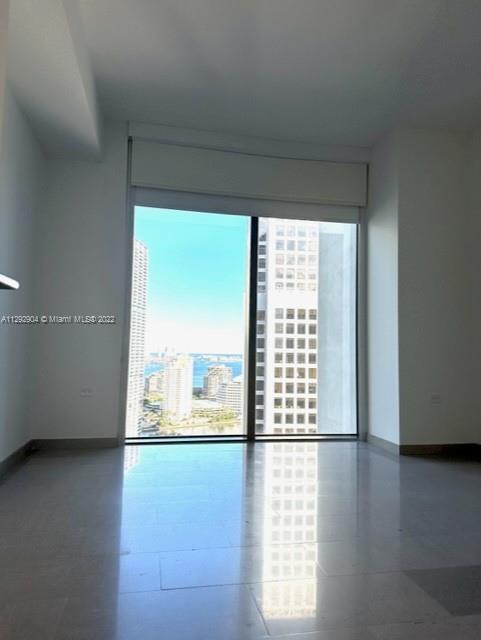 68 Southeast 6th Street, Unit 2507 Miami, FL 33131 - Photo 20 of 46 a view of an empty room with wooden floor and a window