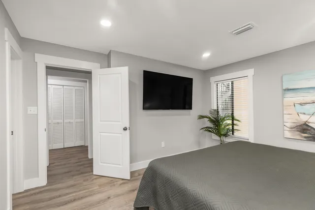 a bathroom with a granite countertop sink a toilet a mirror and shower
