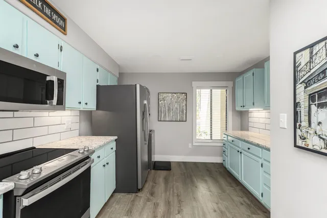 a kitchen view with granite countertop a sink and a wooden floor