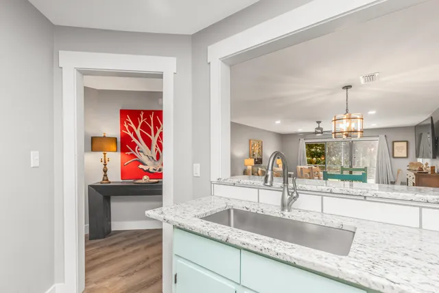a kitchen with granite countertop a sink a stove and cabinets