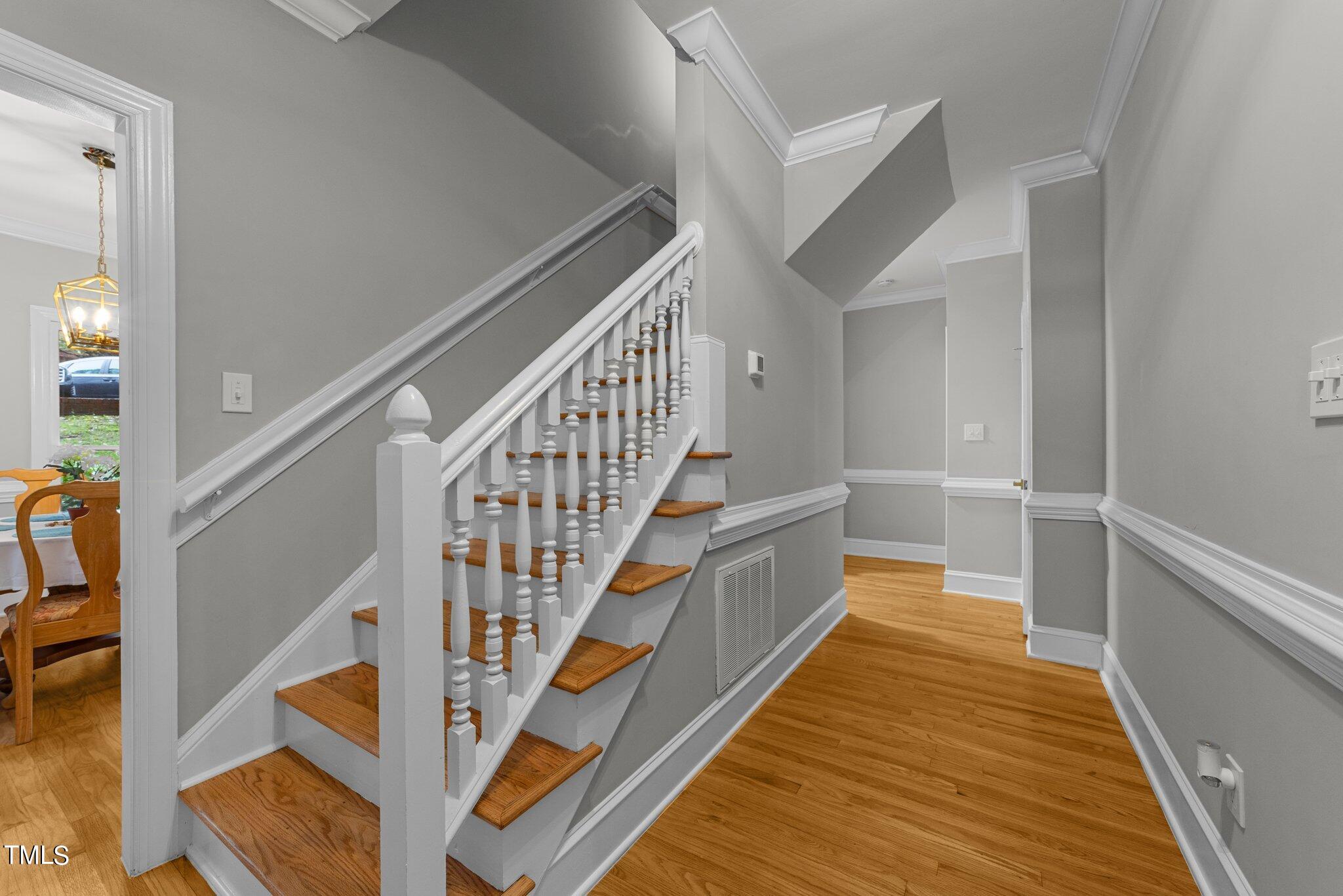 6838 Gloucester Road Raleigh, NC 27612 - Photo 5 of 36 a view of staircase with wooden floor and white walls
