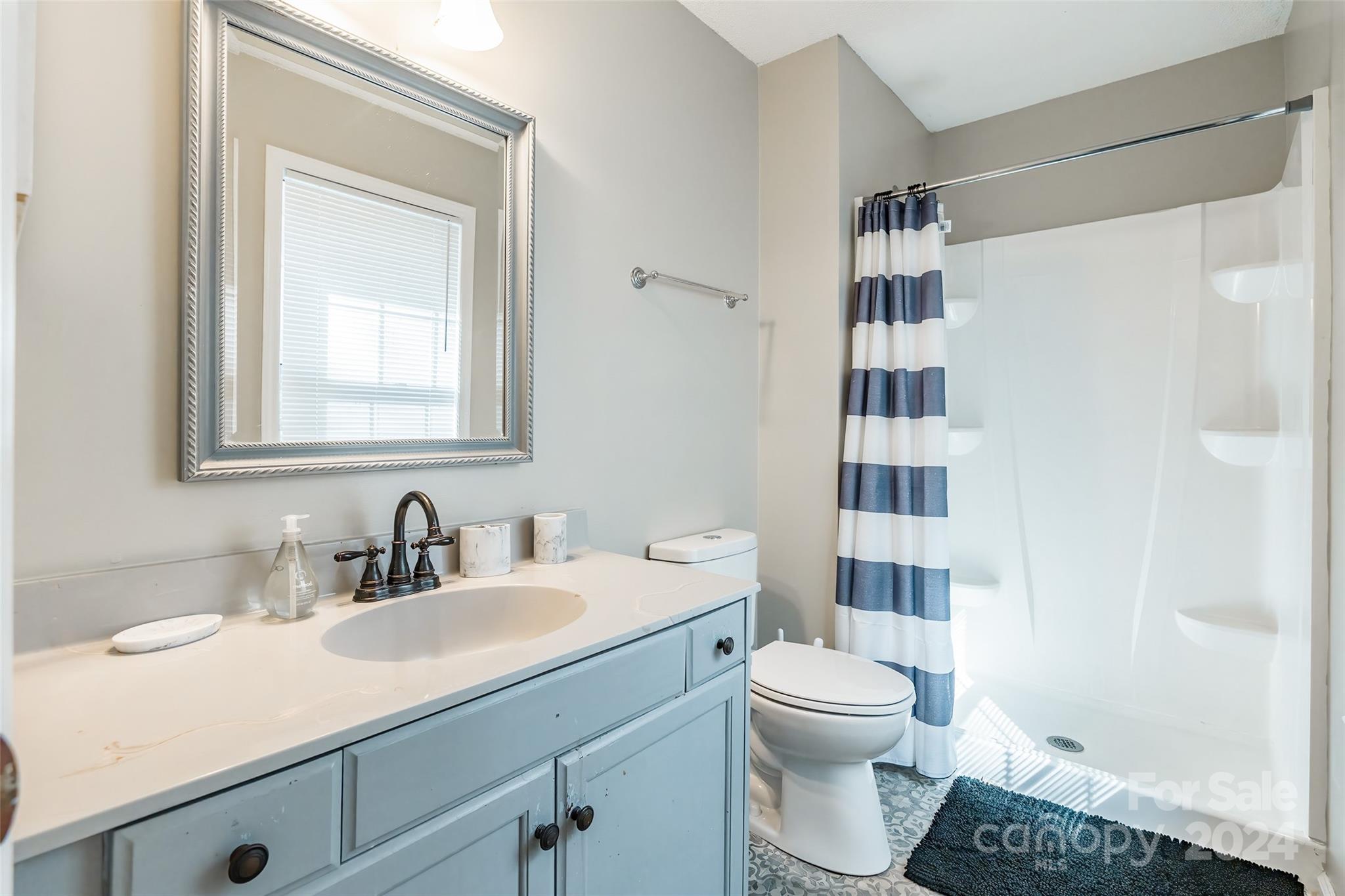 218 Bubbling Well Road Denver, NC 28037 - Photo 15 of 25 a bathroom with a sink toilet vanity and shower