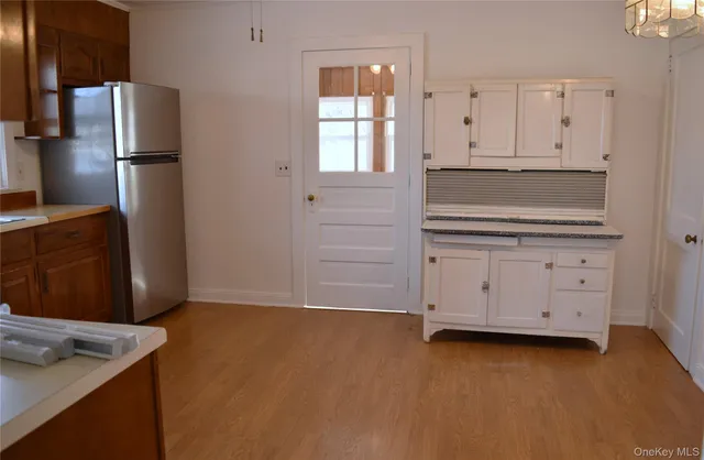 a kitchen with white cabinets and refrigerator