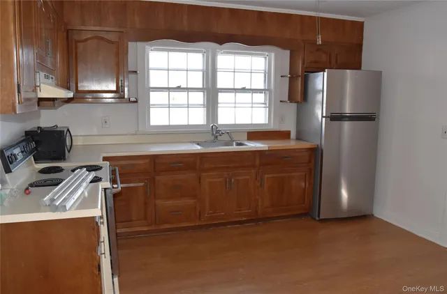 a kitchen with stainless steel appliances granite countertop a sink a refrigerator and a stove