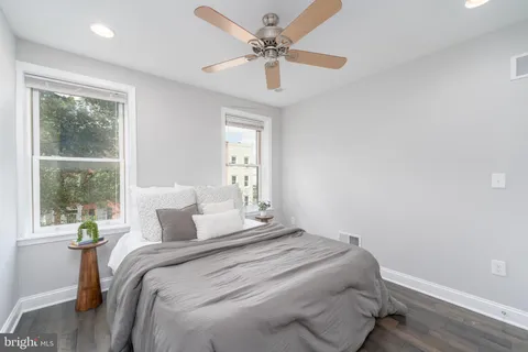 a bathroom with a granite countertop sink a toilet and shower