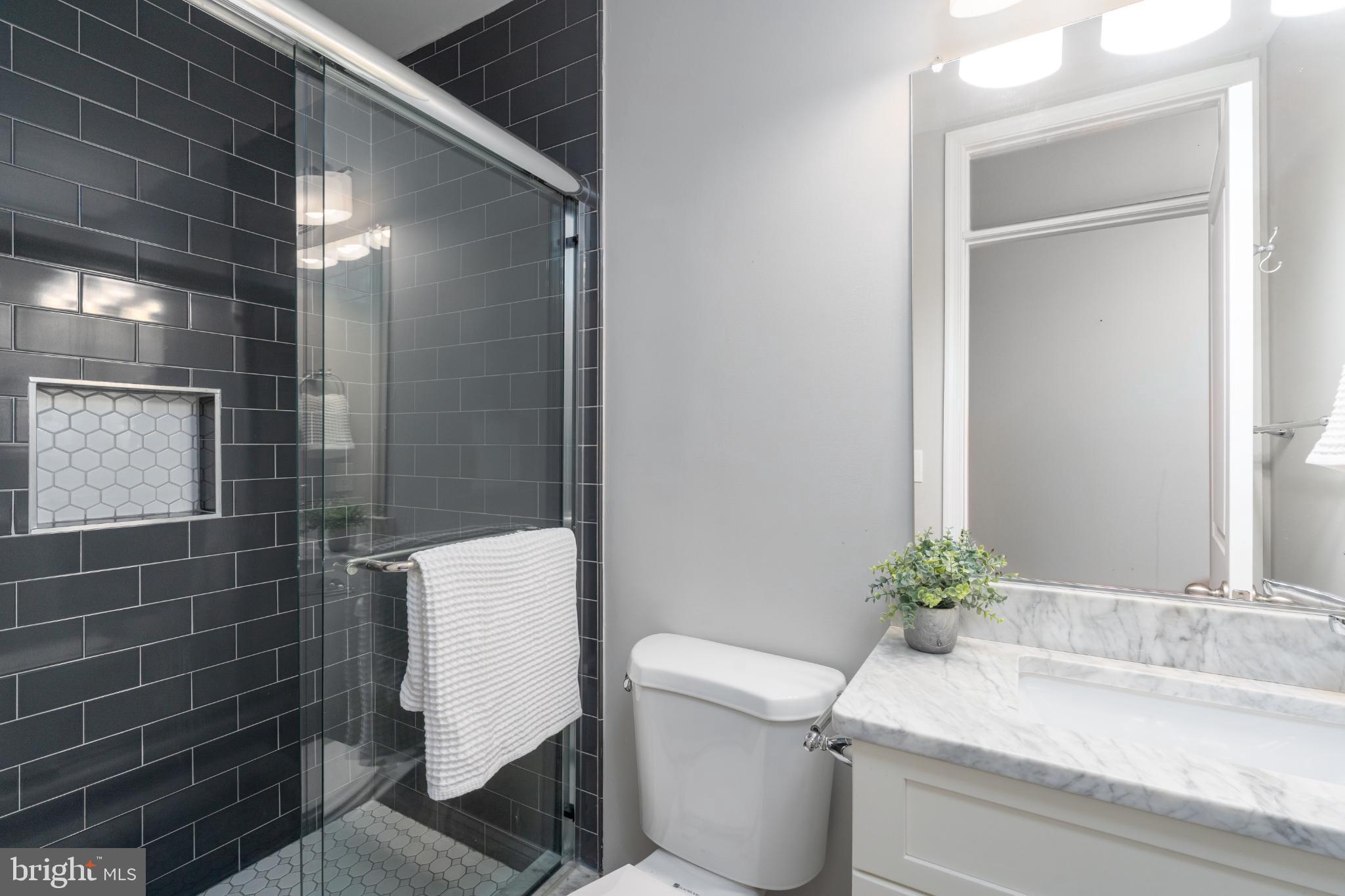 23 South Washington Street Baltimore, MD 21231 - Photo 21 of 57 a bathroom with a granite countertop sink a toilet and shower