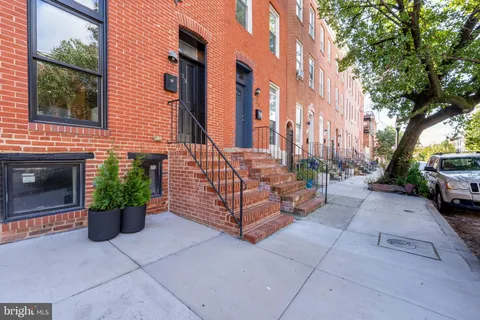 a patio with table and chairs and potted plants