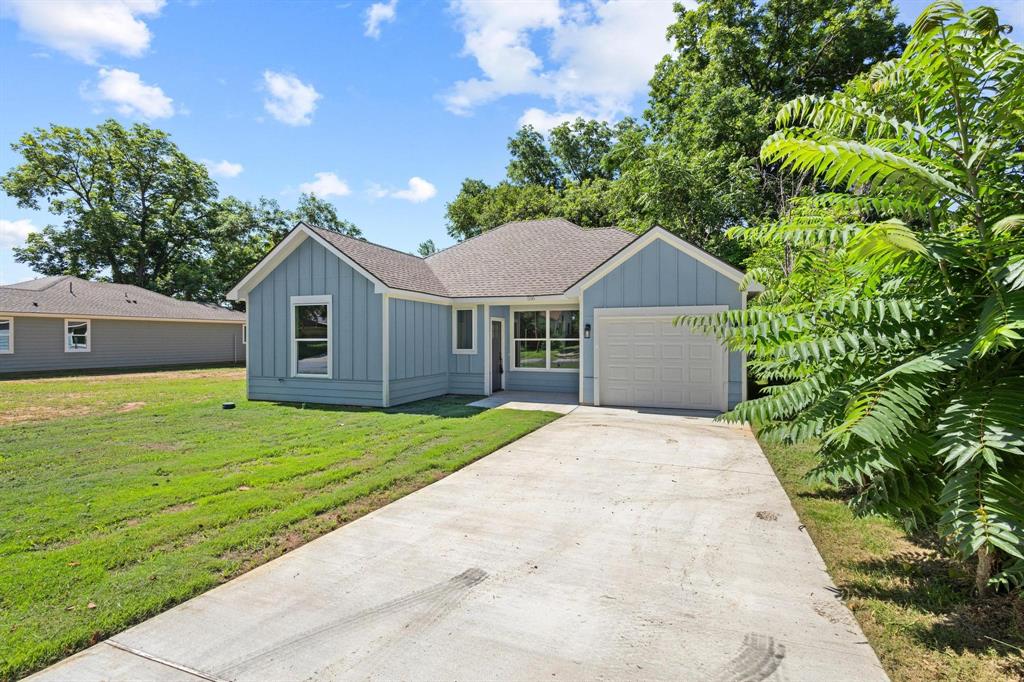 516 Florence Denison, TX 75020 - Photo 2 of 27 a front view of a house with a yard and garage