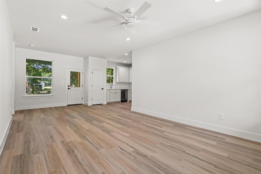 516 Florence Denison, TX 75020 - Photo 5 of 27 an empty room with wooden floor a ceiling fan and windows