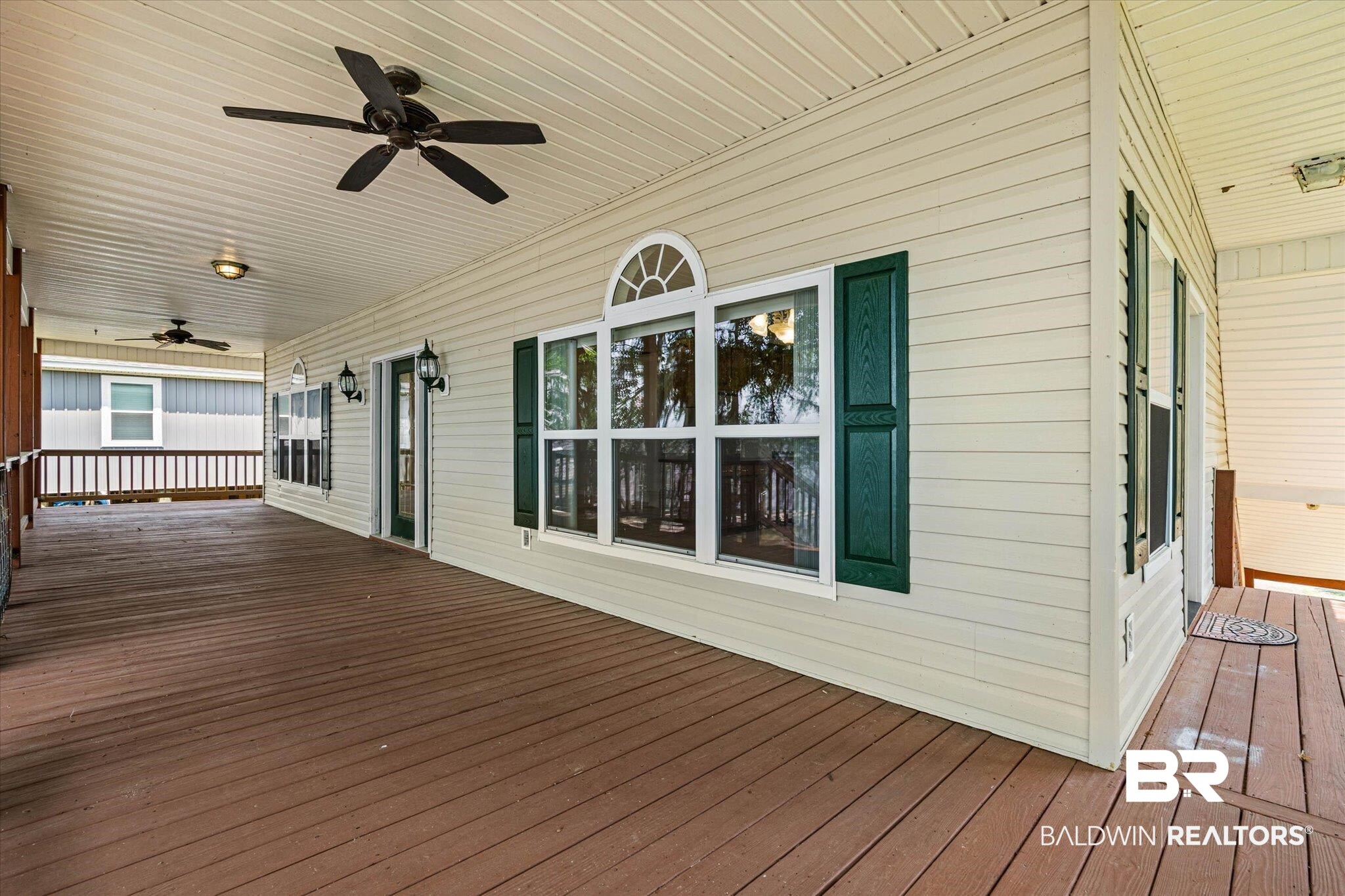 41923 Bayou Road Bay Minette, AL 36507 - Photo 24 of 35 Expansive covered deck featuring wood-finish flooring, two ceiling fans, and multiple outdoor wall sconces
